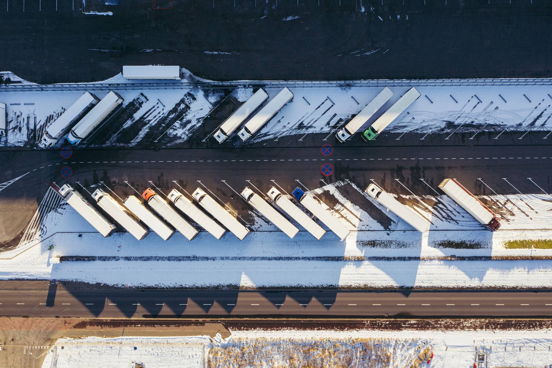 Aerial view of rows of semi-trailers parked at a logistics facility in winter